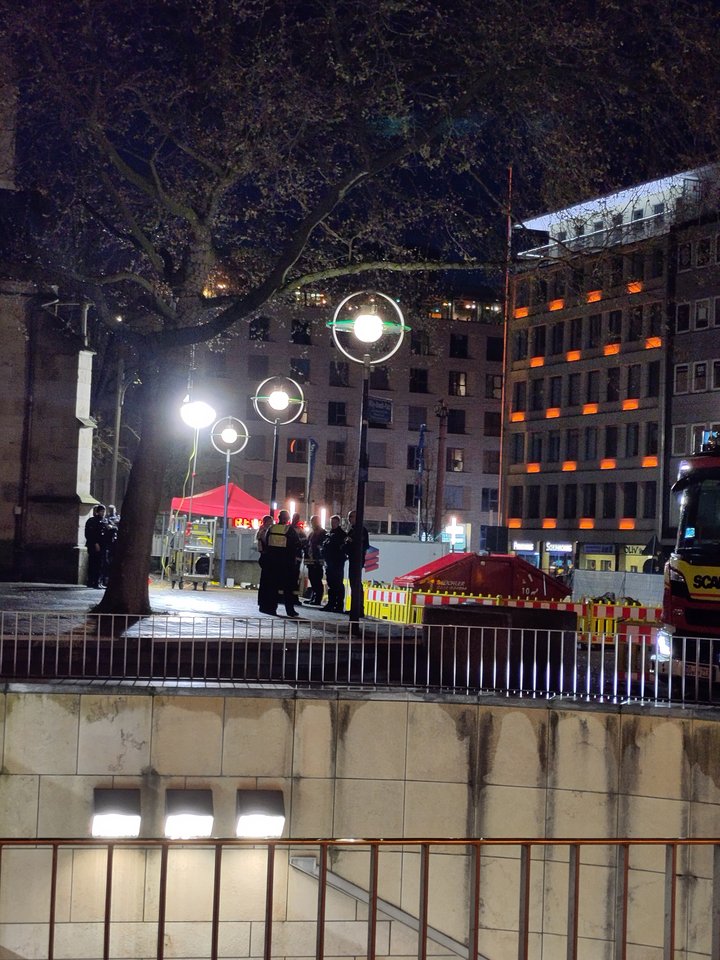 Eine Gruppe Polizisten steht an der Reinoldikirche. Im Hintergrund ist ein Pavillion aufgebaut. Es ist bereits fast dunkel.