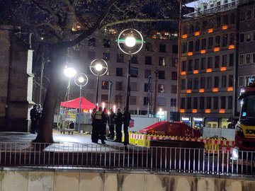 Eine Gruppe Polizisten steht an der Reinoldikirche. Im Hintergrund ist ein Pavillion aufgebaut. Es ist bereits fast dunkel.